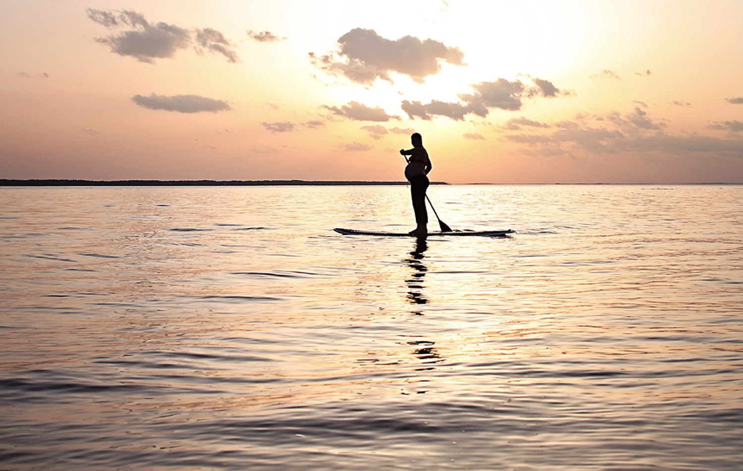 Pregnant silhouette on stand up Paddle board in Nags Head NC