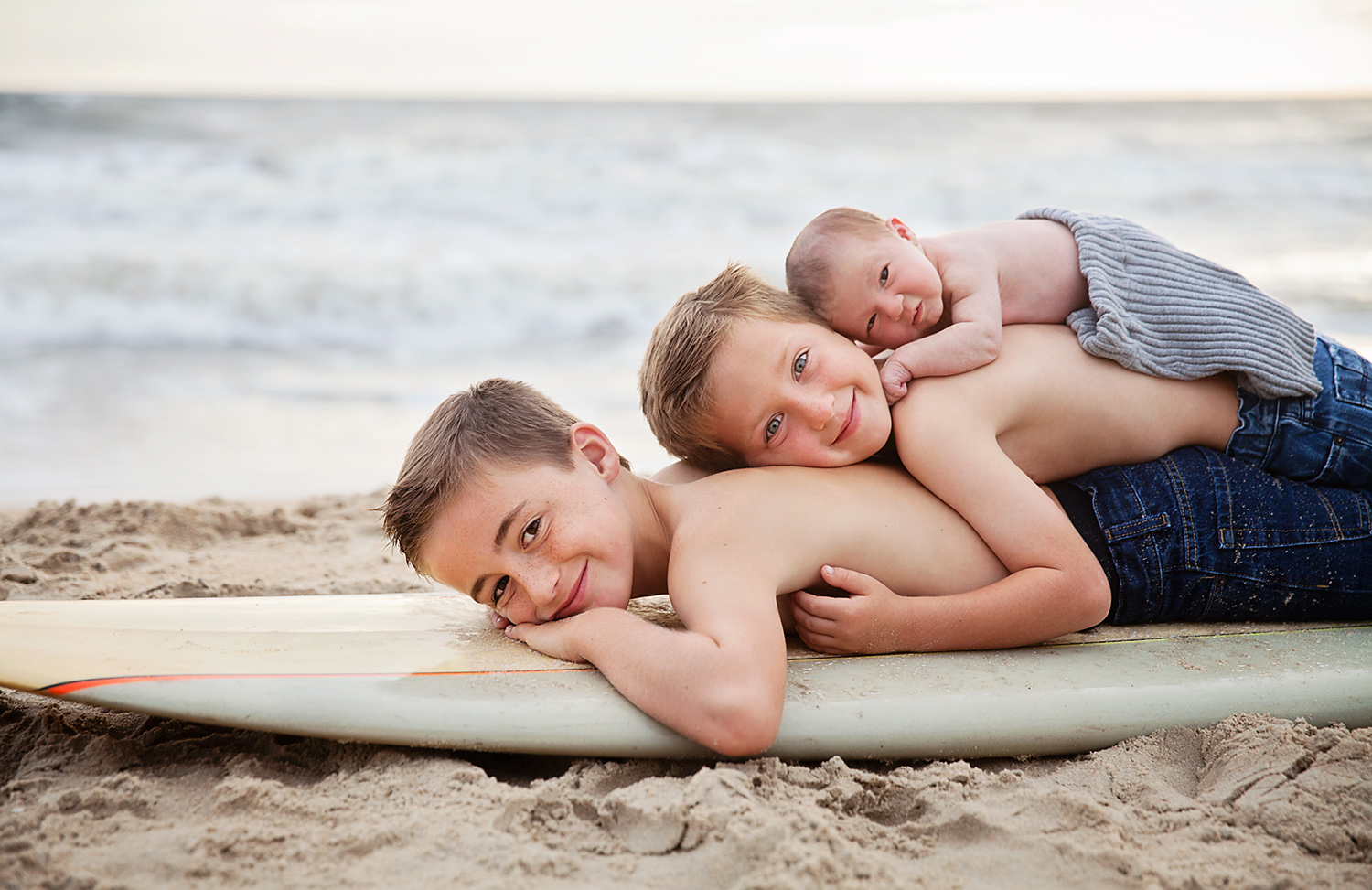 Brothers stacked on a surfboard in Kitty Hawk NC