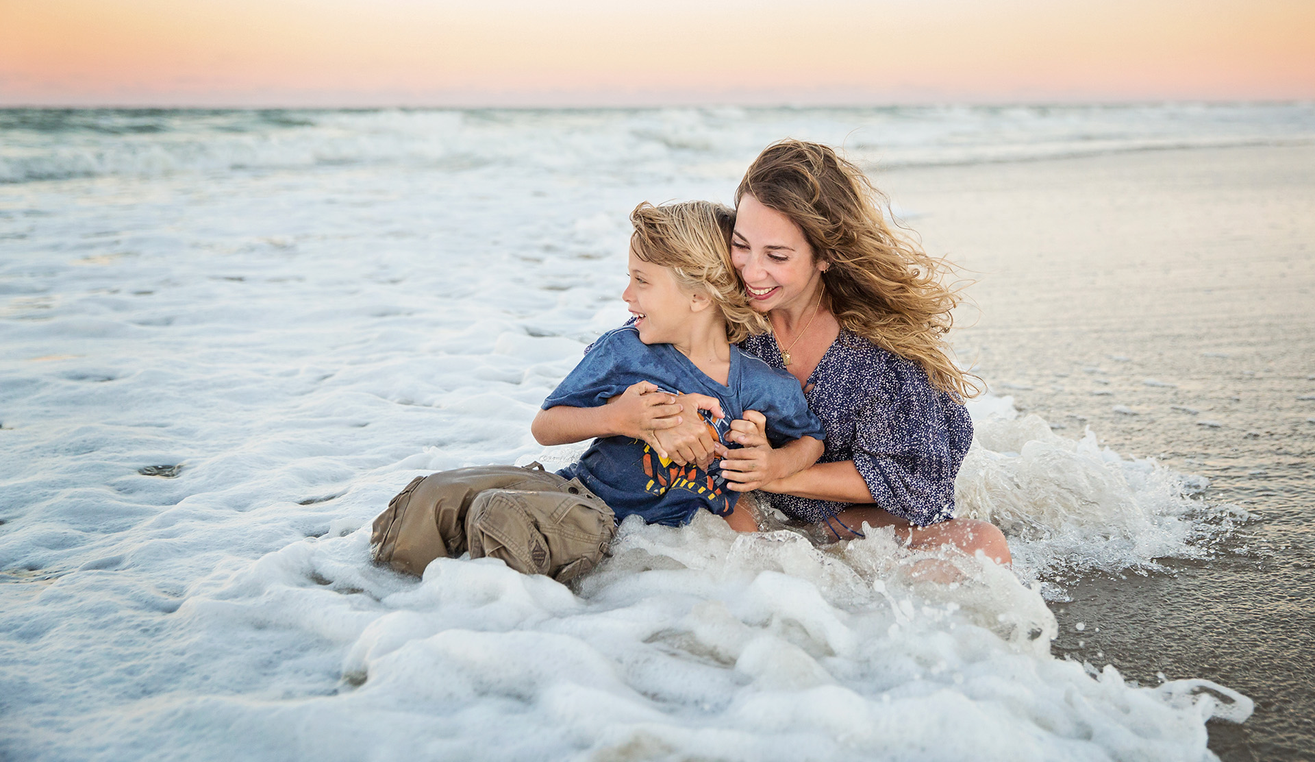 Family photo of Mom and son playing in ocean Corolla NC