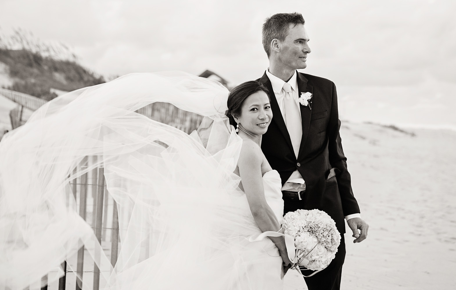 Bride and groom black and white on beach by Jennettes Pier in Nags Head NC