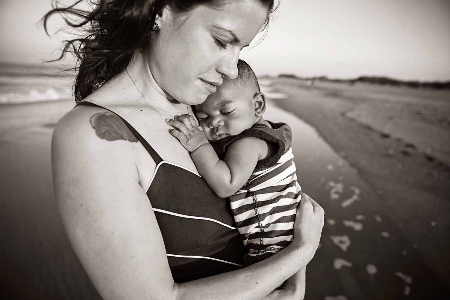 Mother and her newborn snuggle on beaches of Nags Head NC