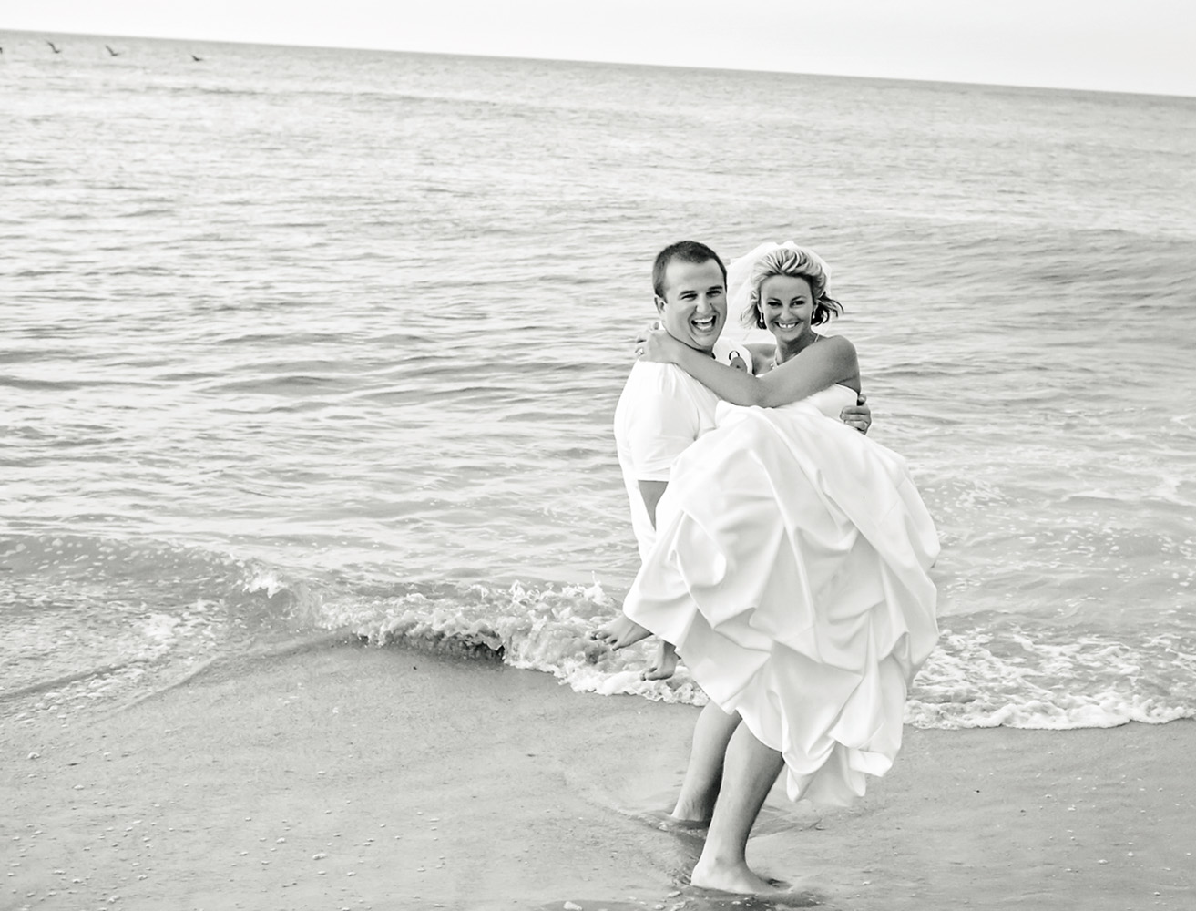 Black and white image of just married couple at the beach