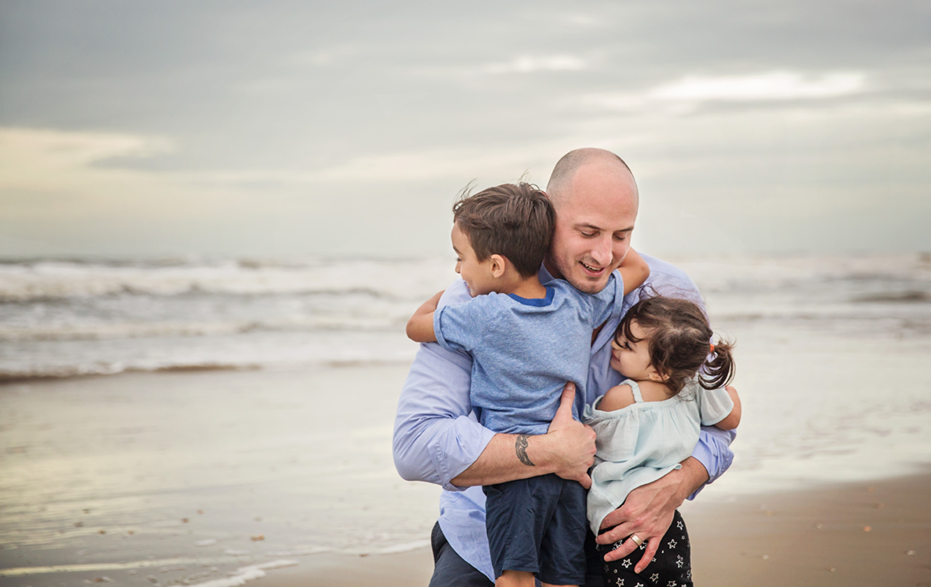 Father hugging kids photo by ocean in Corolla NC