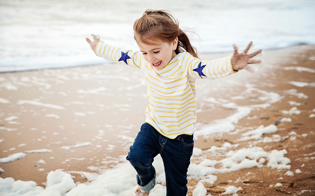 Little Sam plays in the seafoam in Corolla NC